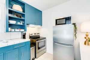 a kitchen with blue cabinets and a refrigerator at Soleil House - Unit D in Galveston