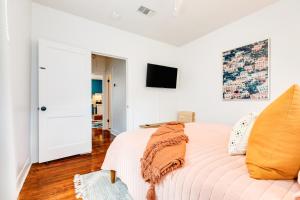 a bedroom with a bed and a tv on the wall at Soleil House - Unit D in Galveston
