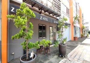 um restaurante com árvores em frente a um edifício em Z Hotel em Petaling Jaya