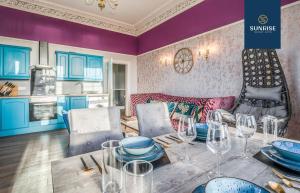 a kitchen and dining room with a table with wine glasses at PRESIDENTIAL Apt, Family Home, Luxury Bedrooms, 2 Rooms, 1 King Bed, 2 Single Beds, Free WiFi, Free Parking, FAVOURITE for Families, Tourists, Business Travelers, Relocation, Beautiful Sea Views in Dundee