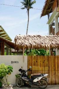 a motorcycle parked in front of a building with a palm tree at Diwa Siargao Eco-House in General Luna