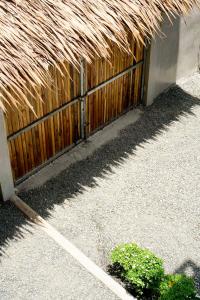a wooden fence with a thatched roof at Diwa Siargao Eco-House in General Luna