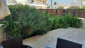 a patio with a chair and plants and a fence at Melania Gardens in Paphos City
