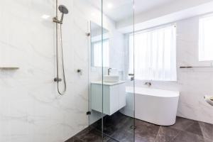 a white bathroom with a sink and a shower at The Bay House Shoal Bay huge five bedroom holiday home with WiFi and Foxtel in Shoal Bay +30 photos