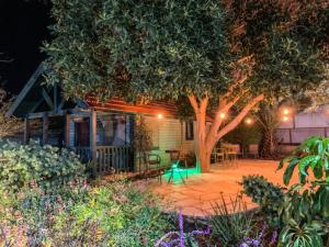 una casa con un árbol y un patio por la noche en Song of Galilee, en Elifelet
