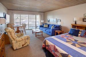 a bedroom with a bed and a couch and a table at Lanai at the Cove in Seaside