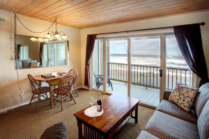 a living room with a couch and a table and a balcony at Lanai at the Cove in Seaside