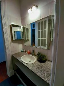 Hostel B&B Tandil في تانديل: حمام مع حوض ومرآتين
