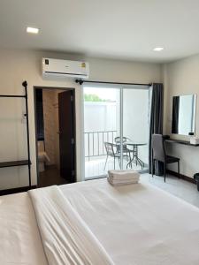 een slaapkamer met een bed en een balkon met een tafel bij see-on place/สีอ่อนเพลส in Ban Tha Phae