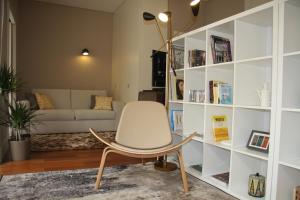 ein Wohnzimmer mit einem Stuhl und einem Sofa in der Unterkunft Toctoc Yellow in Porto