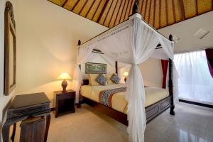 a bedroom with a bed with a canopy at Queen Bisma Villa - 10 min walking to Ubud Center in Ubud
