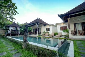 eine Villa mit einem Pool vor einem Haus in der Unterkunft Queen Bisma Villa - 10 min walking to Ubud Center in Ubud