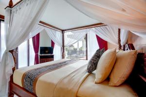 ein Schlafzimmer mit einem Himmelbett und einem Fenster in der Unterkunft Queen Bisma Villa - 10 min walking to Ubud Center in Ubud