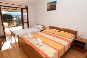 um quarto com 2 camas e uma varanda em Apartments Ante - 50 M from the sea em Seget Vranjica