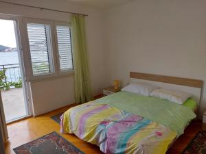 ein Schlafzimmer mit einem Bett und einem großen Fenster in der Unterkunft Apartment Bila - 15m from the sea in Tisno