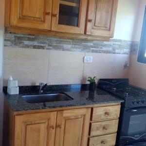 a kitchen counter with a sink and a stove at Complejo Yvy Porá in Goya