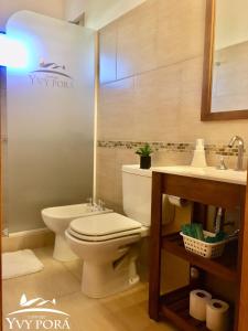 a bathroom with a toilet and a sink at Complejo Yvy Porá in Goya