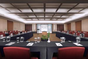 a conference room with tables and chairs and a podium at Grand Dafam Braga Bandung in Bandung