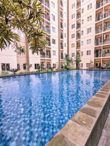 einem Pool vor einem Gebäude in der Unterkunft Cottonwood Apartment at Sudirman Suites Bandung 5-pax in Bandung