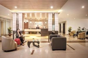 Ein Mann, der auf einer Couch in der Lobby sitzt. in der Unterkunft Cottonwood Apartment at Sudirman Suites Bandung 5-pax in Bandung