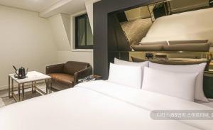 a hotel room with a bed and a chair at Newmond Hotel in Seoul