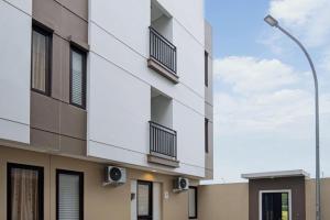 an apartment building with balconies and a street light at TwoSpaces Living at Zena Mozia in Tegal