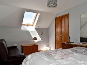 a bedroom with a bed and a chair and a window at Cider Cottage - Uk11861 in North Tamerton