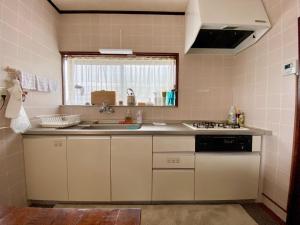 a small kitchen with a sink and a stove at ホライゾン in Oshima