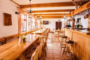 un restaurante con mesas de madera y un bar en Penzion Kozel - Herlíkovice Krkonoše, en Vrchlabí