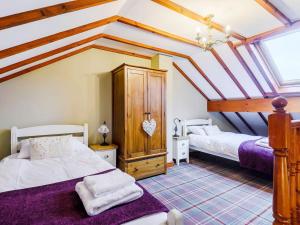 a bedroom with two beds in a attic at Beudy - Uk31388 in Caeathro