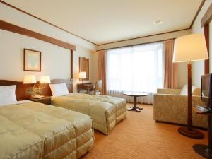 a hotel room with two beds and a couch at Hotel Onikoube in Osaki