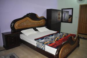 um quarto com uma cama com uma estrutura em madeira em Hotel The Oriel Islamabad em Islamabad