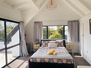 a bedroom with a bed with a teddy bear on it at Rotorua redwood retreat in Rotorua
