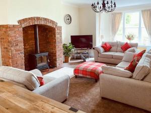 sala de estar con 2 sofás y chimenea en Heath View, en Cheddleton