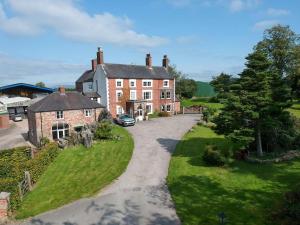 an aerial view of a large brick house with a driveway at Heath View in Cheddleton