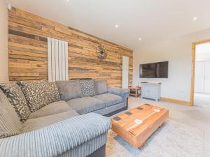 sala de estar con sofá y pared de madera en The Lodge en Dalton in Furness