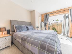 1 dormitorio con cama y ventana grande en The Lodge, en Dalton-in-Furness