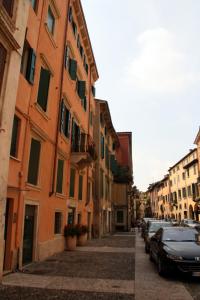 een smalle straat met auto's geparkeerd aan de zijkant van een gebouw bij Sottoriva36 in Verona