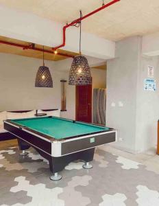 a pool table in a living room with two lights at Charming Zen-style Beach apartment at Punta Caelo in San Carlos
