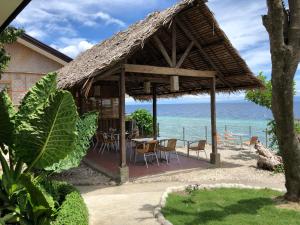 una capanna con tavolo e sedie sulla spiaggia di Tipolo Beach Resort a Moalboal