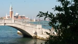a bridge over the water with a city in the background at La Casa del Mercante Veneziano in Venice