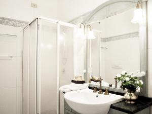 a white bathroom with a sink and a mirror at La Casa del Mercante Veneziano in Venice