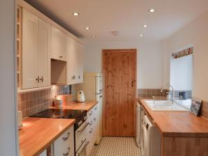a kitchen with white cabinets and a wooden door at North View in Bradwell