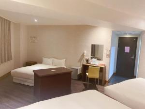 Cette chambre comprend deux lits et un bureau. dans l'établissement Centre Hotel, à Kaohsiung