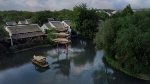 a boat in a river next to some buildings at Banyan Tree Hangzhou in Hangzhou