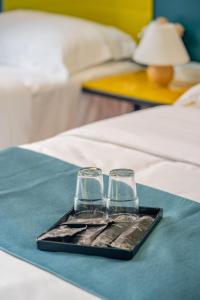 a tray with two wine glasses on a bed at Hotel 28 Chow Kit Kuala Lumpur in Kuala Lumpur