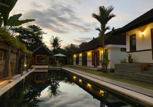 a villa with a pool in front of a house at Agung Village in Tanah Lot