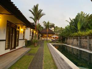 una casa con piscina al lado de una casa en Agung Village, en Tanah Lot
