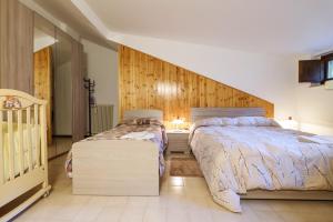 a bedroom with two beds and a crib at Cambrembo a 3km da foppolo casa x6persone con Camino e Wifi in Valleve