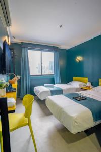 um quarto de hotel com quatro camas e uma janela em Hotel 28 Chow Kit Kuala Lumpur em Kuala Lumpur